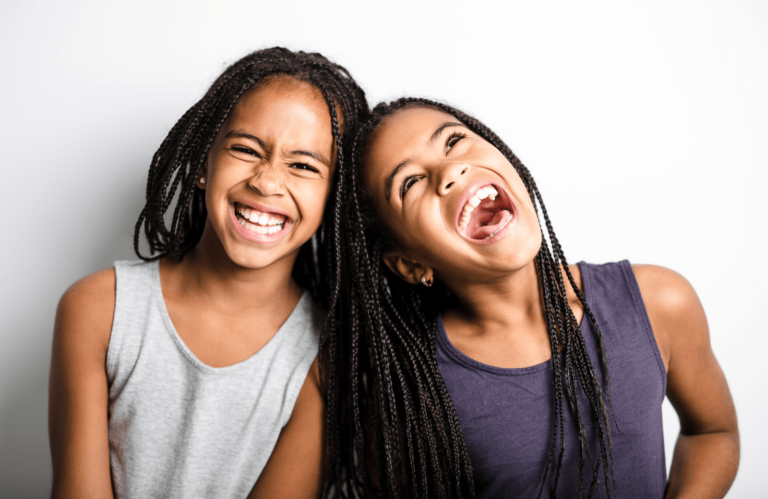 two girls smile after getting braces at age 7