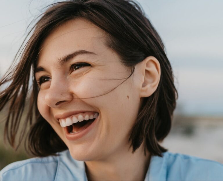 Close-up of a smiling teen with a retainer maintaining her orthodontic results