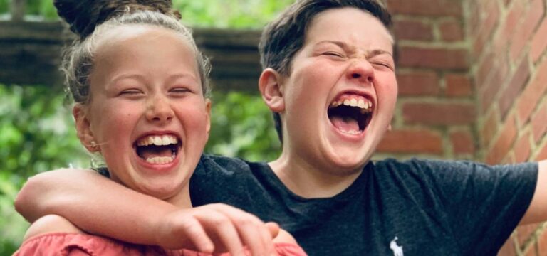 sibling hug and laugh while learning what causes crowded teeth