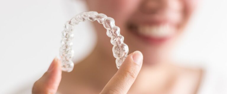 adult holds aligner and learns invisalign tips